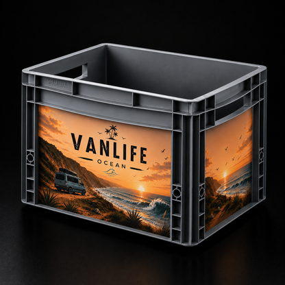 Auer Eurobox 40 × 30 × 27 cm mit passgenauem Vanlife Ocean Sticker-Set. Das Motiv zeigt einen Campervan am Strand bei Sonnenuntergang mit Wellen, Steilküste und Palmen im Vintage-Look. Die Aufkleber sind sauber auf Front- und Seitenfläche der grauen Eurobox angebracht.