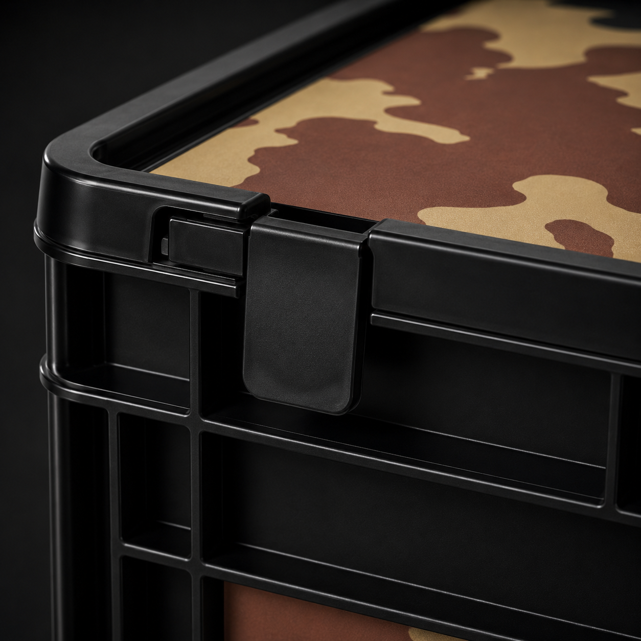 Detailaufnahme vom Verschluss einer schwarzen Eurobox mit Classic Camouflage Folierung und strukturierter Oberfläche.
